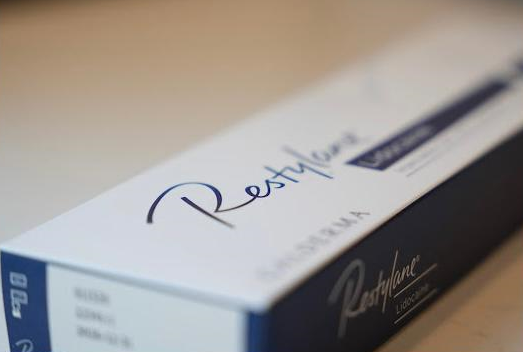 Box of Restylane dermal filler product. Blue and white with the brand name.