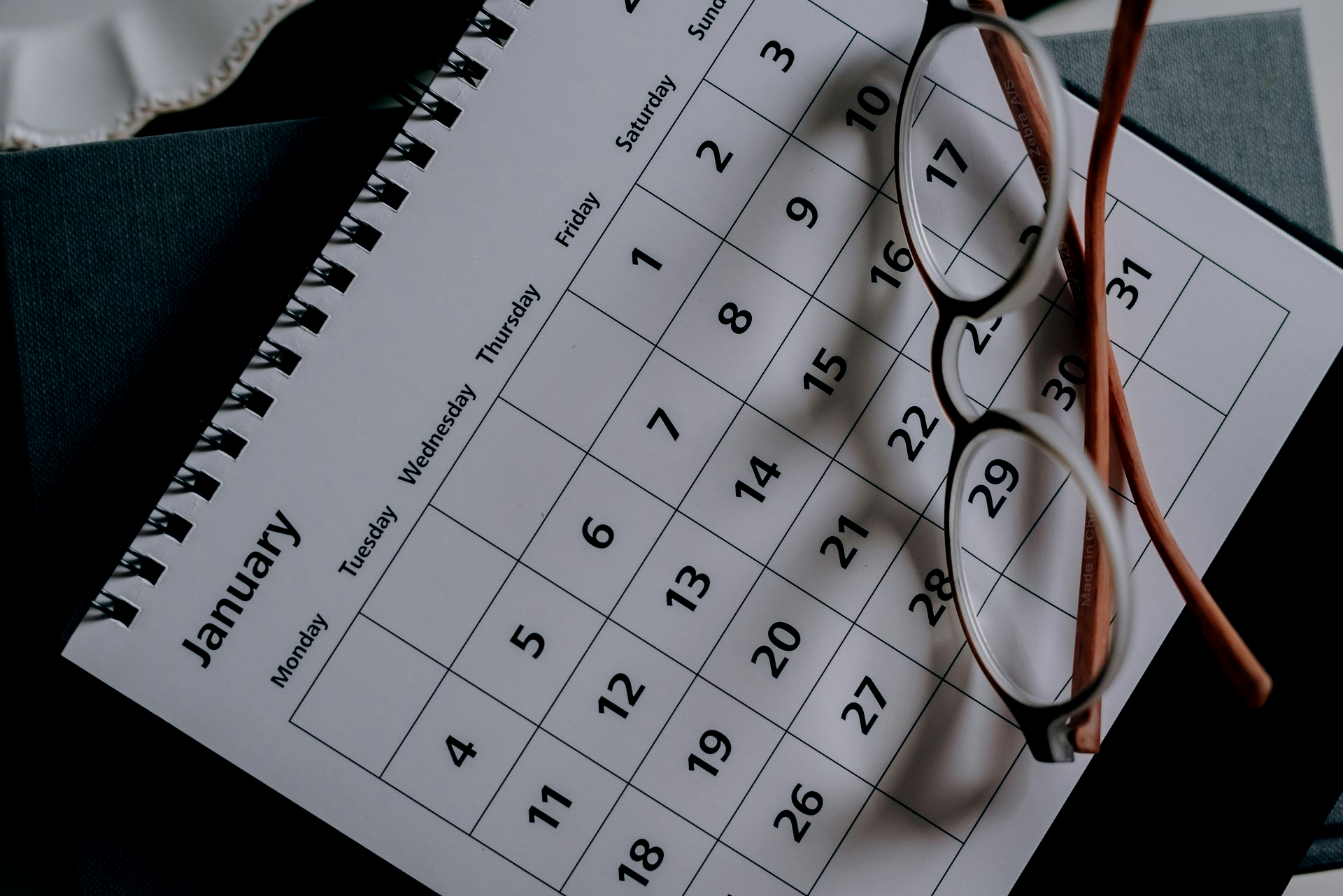 Calendar page open to January, with glasses resting on it.
