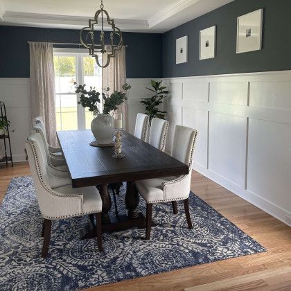 A dining room with a table and chairs and a rug