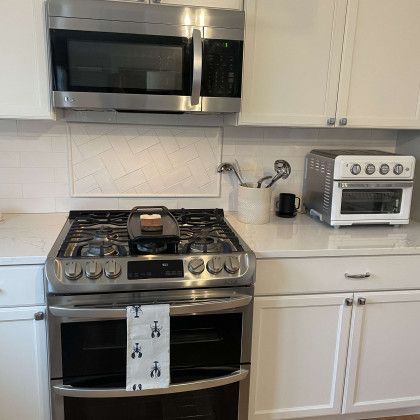 A kitchen with a stove , oven , microwave and toaster oven.