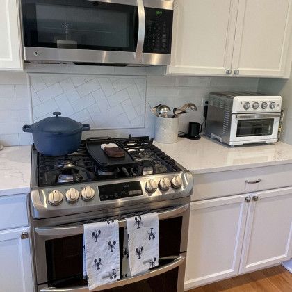 A kitchen with a stove , microwave , and oven.