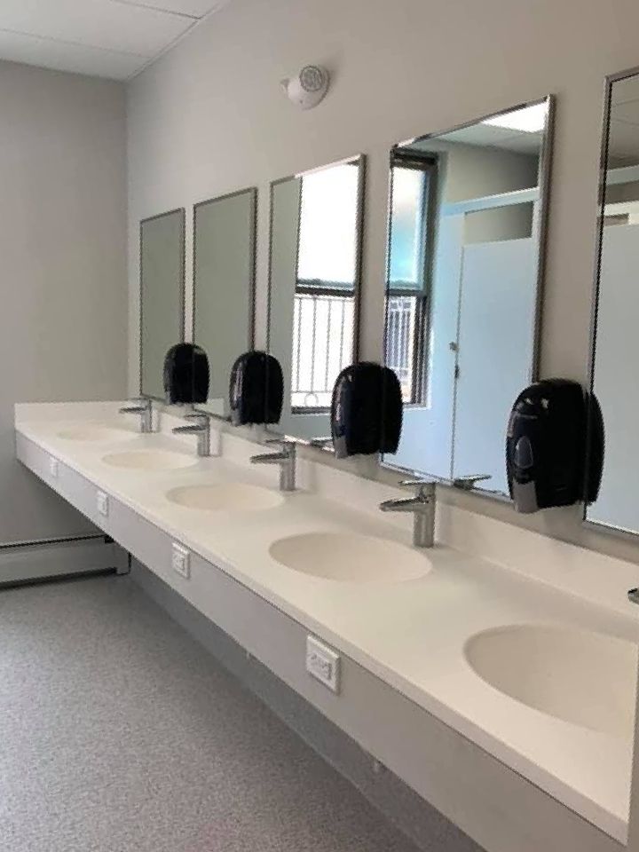 A stainless steel kitchen sink with a black counter top