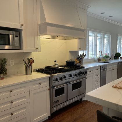 A kitchen with stainless steel appliances and white cabinets