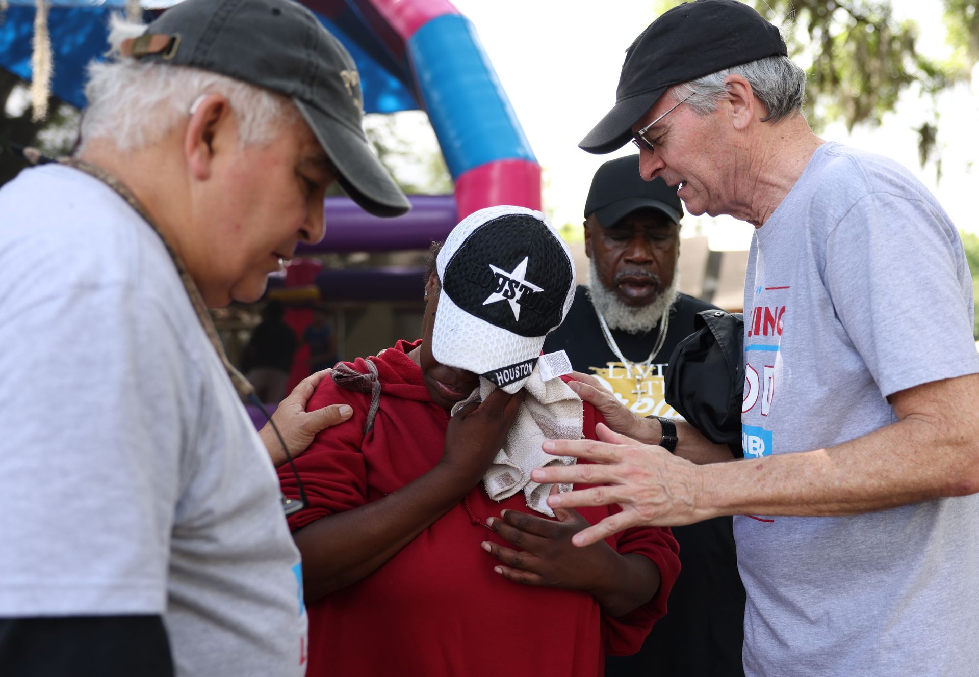 Father Reid prays over a neighbor in North Lake Wire
