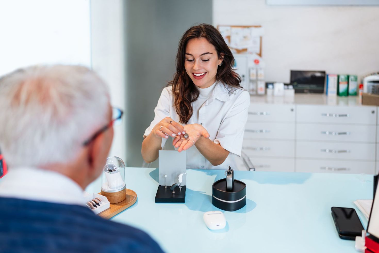 Dentist demonstrating a dental model to a seated patient in a bright clinic