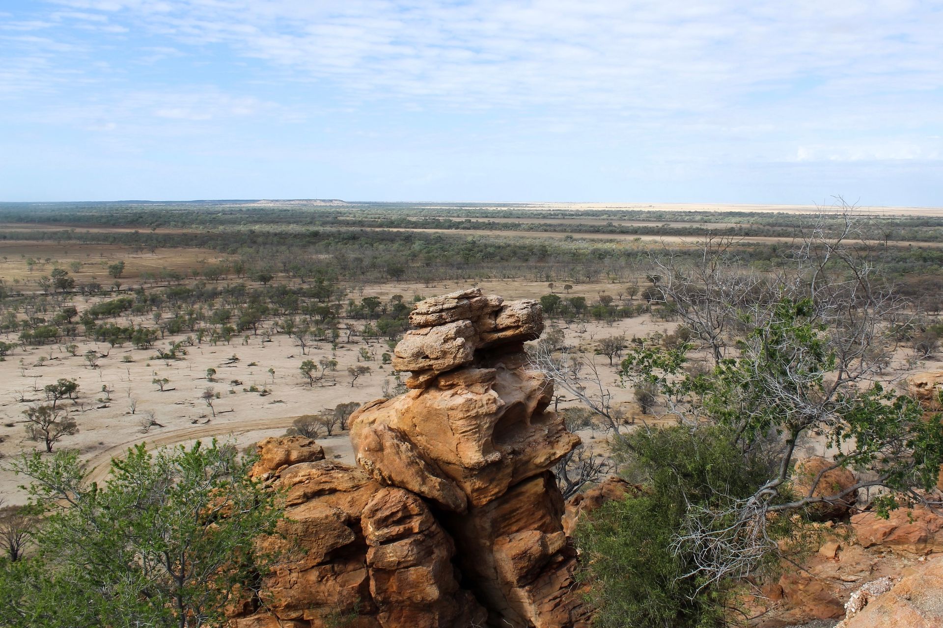 Rocky Outcrop Overlooks A Sparse, Arid Landscape Under A Blue Sky — Mount Isa Skips In Cloncurry, QLD