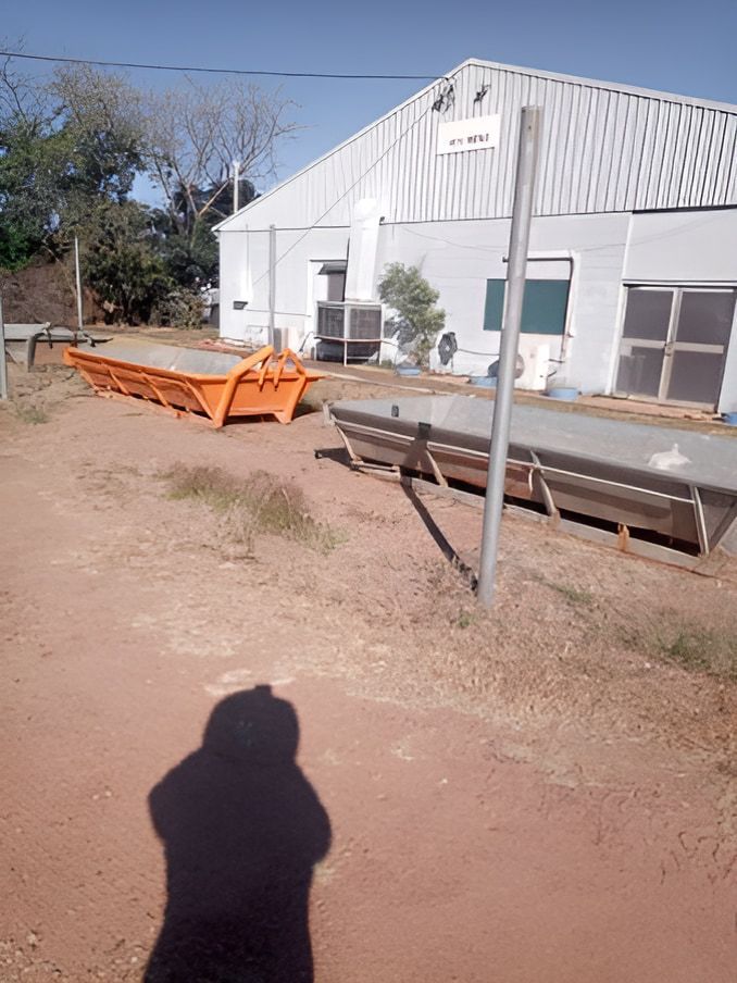 An Orange Dumpster Sitting On The Dirt Ground — Mount Isa Skips In Mount Isa, QLD