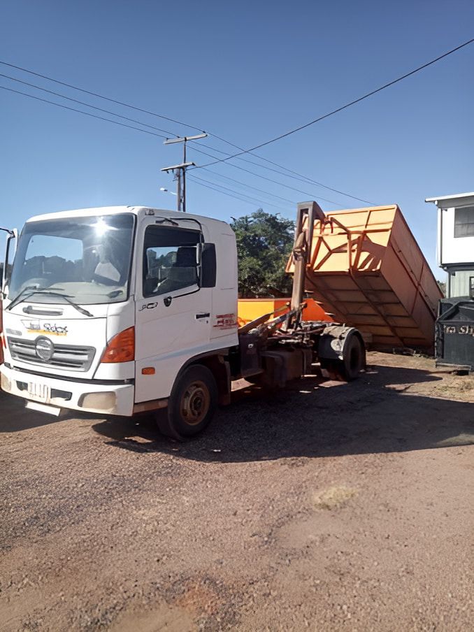 A Dump Truck Is Parked On The Side Of The Road Next To A Building — Mount Isa Skips In Mount Isa, QLD