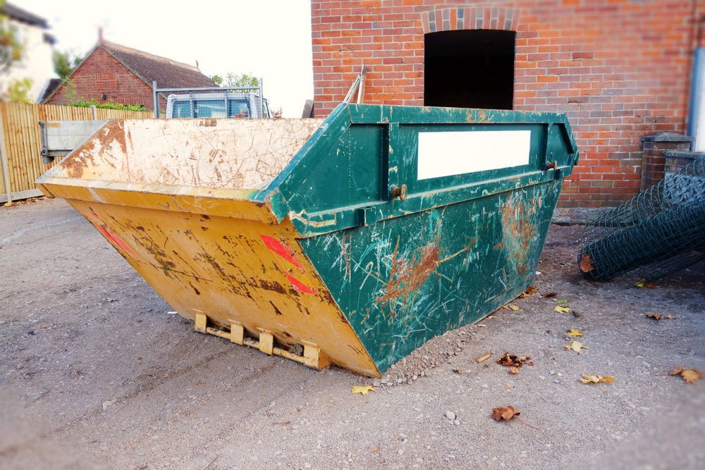 Green and Yellow Metal Dumpster on a Gravel Surface — Mount Isa Skips In Camooweal, QLD