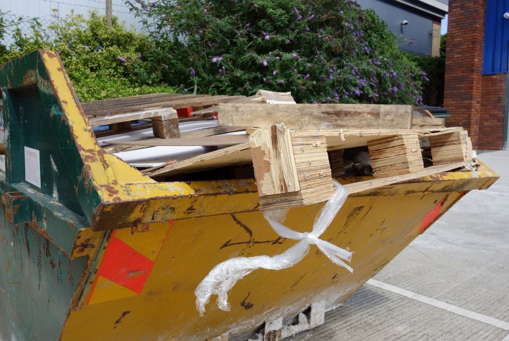 Yellow Dumpster Filled With Wooden Pallets — Mount Isa Skips In Cloncurry, QLD