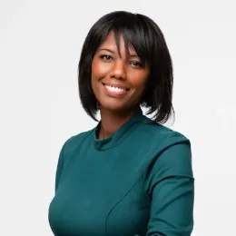 A woman in a green dress is smiling for the camera.