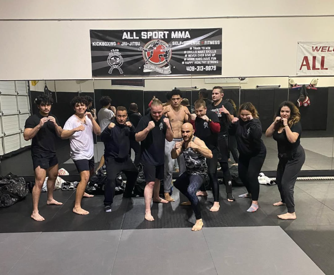 A group of people are posing for a picture in a gym.