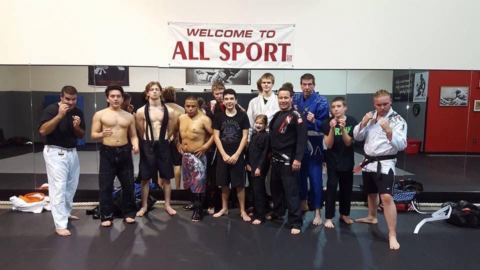 A group of people standing in front of a sign that says welcome to all sport