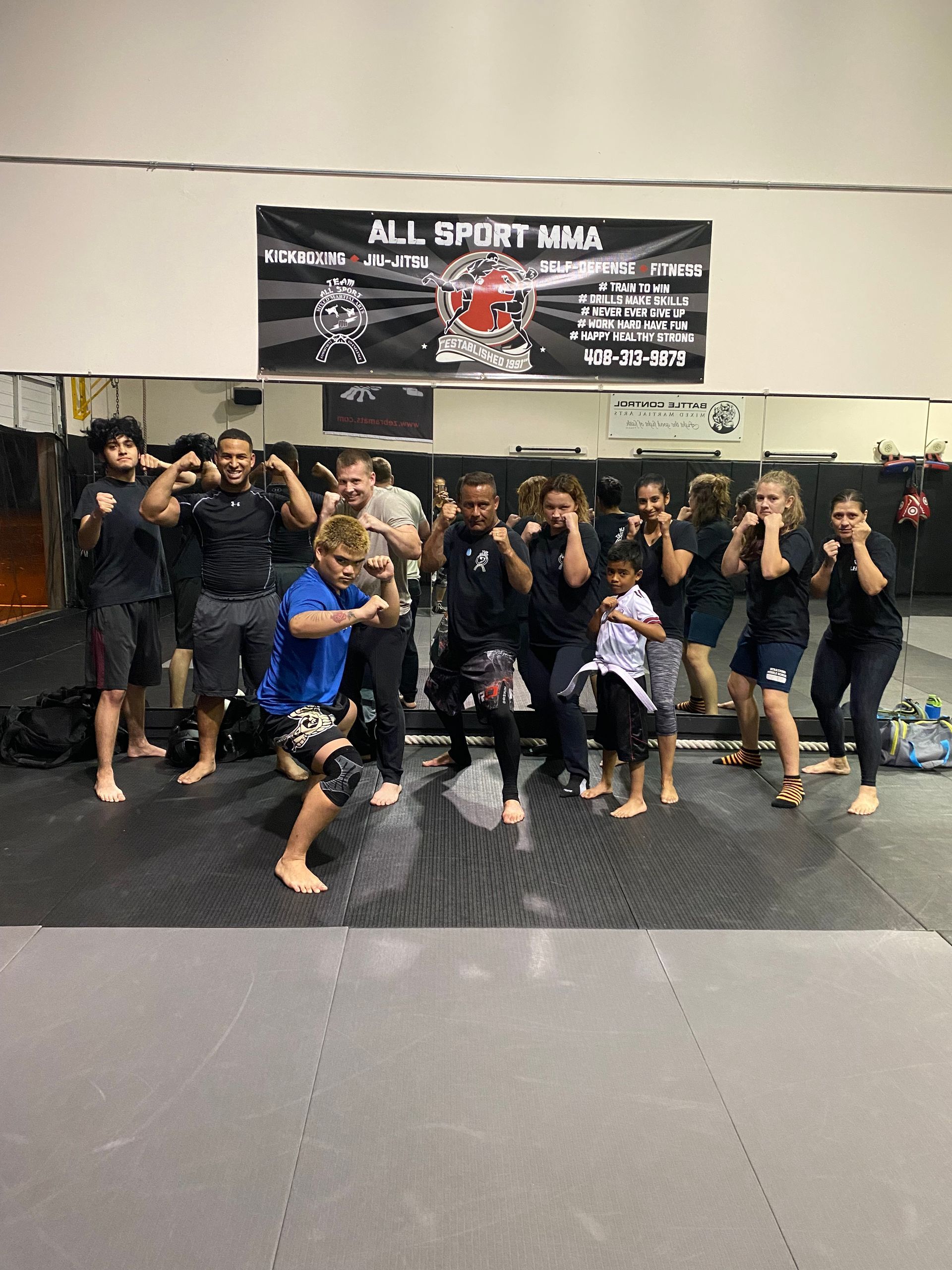 A group of people are posing for a picture in a gym.