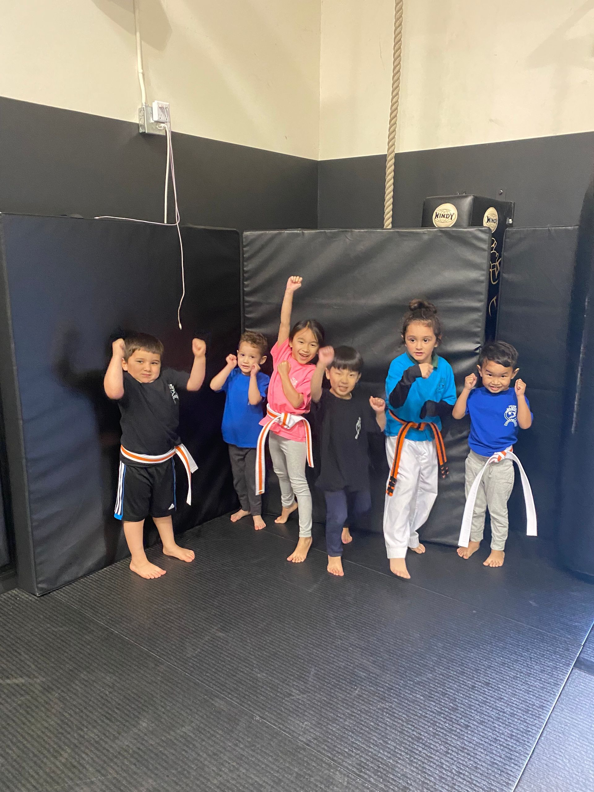 A group of children are posing for a picture in a gym.