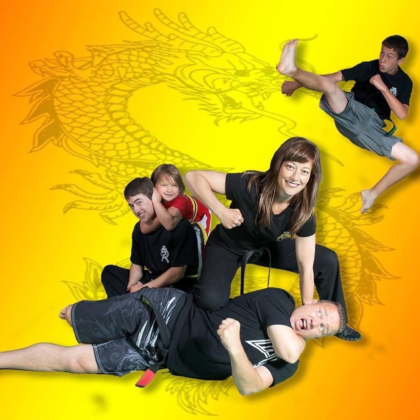 A group of people are posing for a picture with a dragon in the background