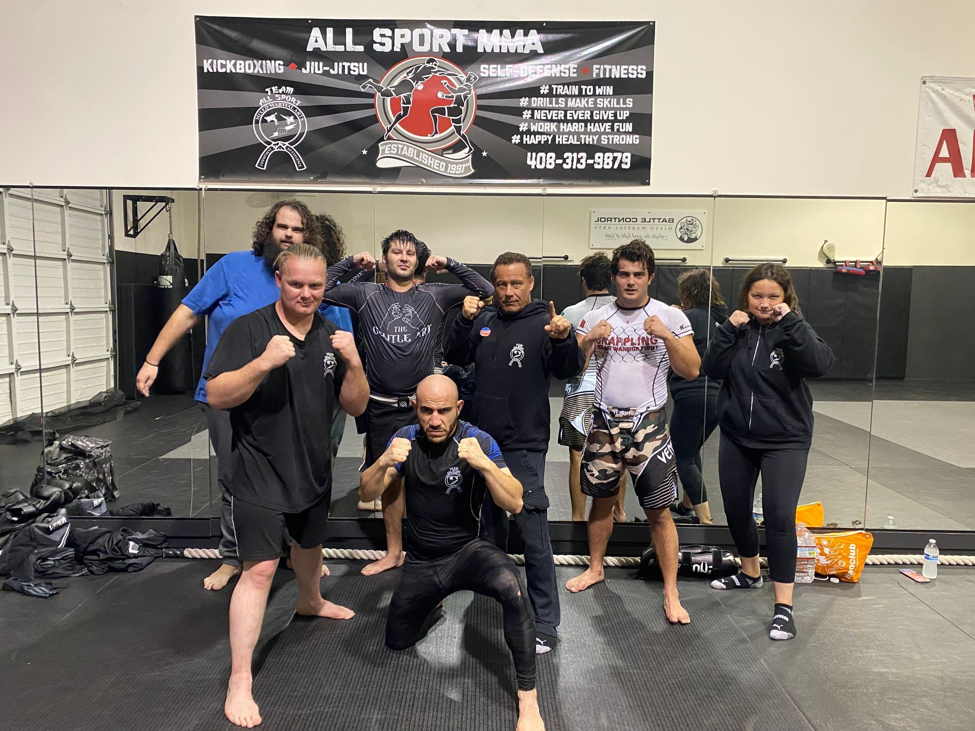 A group of people are posing for a picture in a gym.