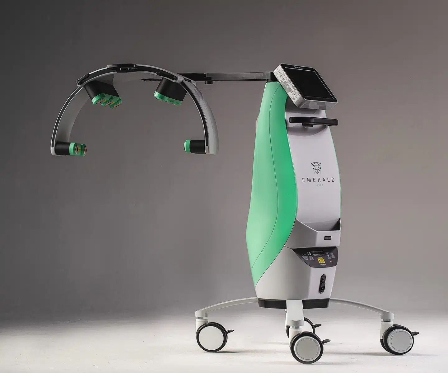A green and white machine with wheels is sitting on a table.