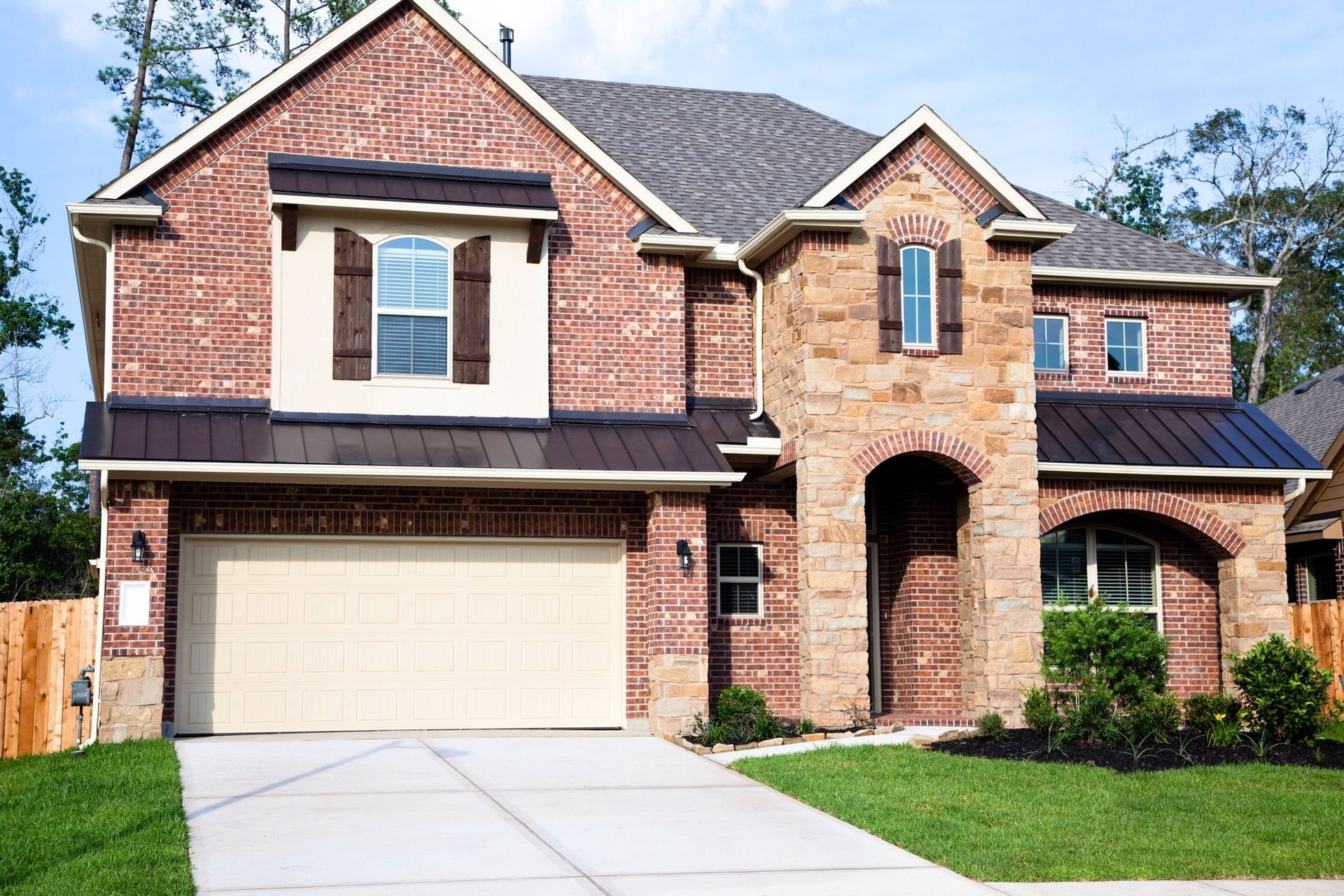 A large brick house with a tan garage door