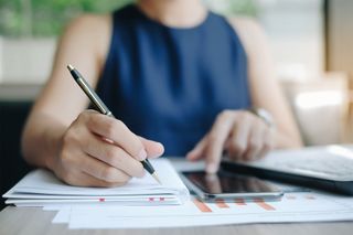 Woman Writing Financial Report — Bradenton, FL — Peninsula Asset Management
