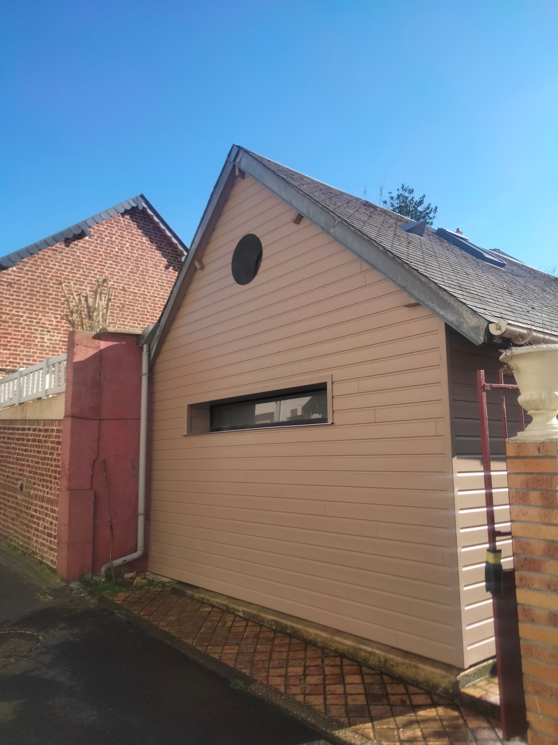 Une grande maison avec deux portes de garage et une allée devant.