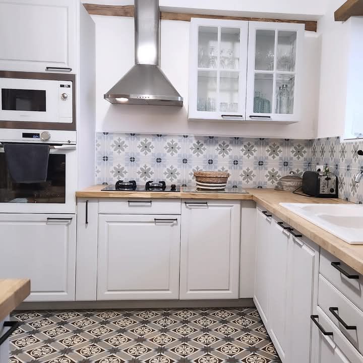 Une cuisine avec des armoires blanches et un four à plaques de cuisson à Fécamp en Normandie