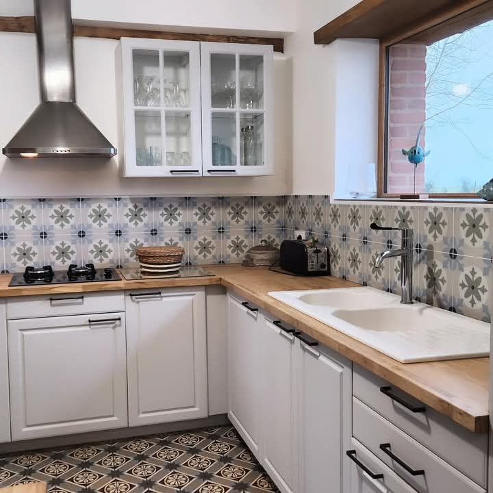 Une cuisine avec des armoires blanches et un évier à Fécamp en Normandie