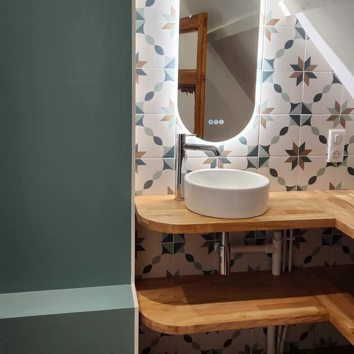 Une salle de bain avec un lavabo rond et un miroir à Fécamp en Normandie