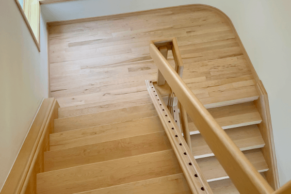 Looking down a wooden staircase with a railing