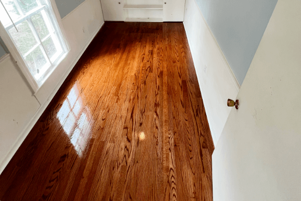 An empty room with hardwood floors and a window