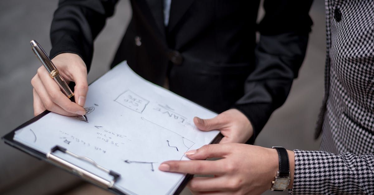 A man and a woman are signing a document on a clipboard.