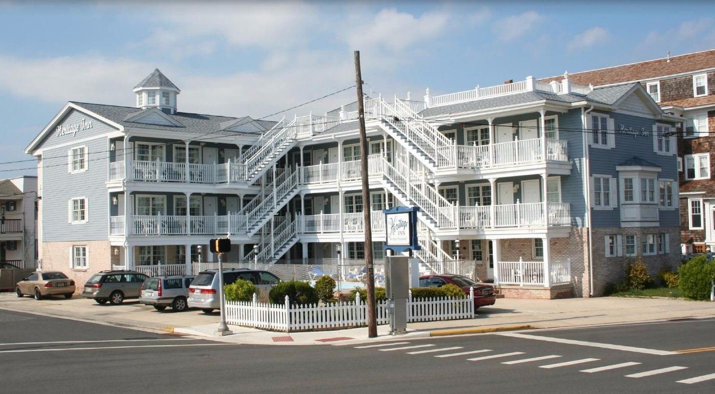 A large building with stairs and cars parked in front of it