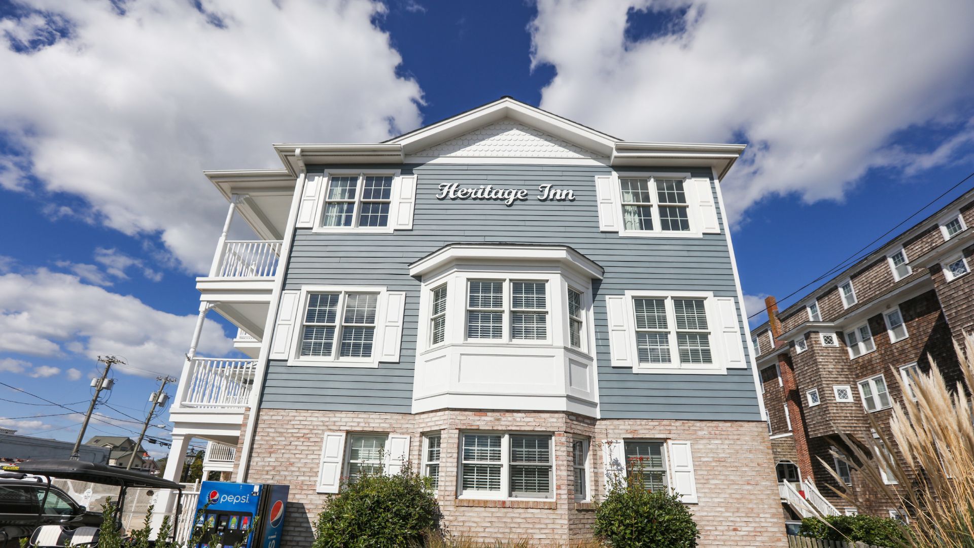 A large house with a lot of windows and shutters on a sunny day.