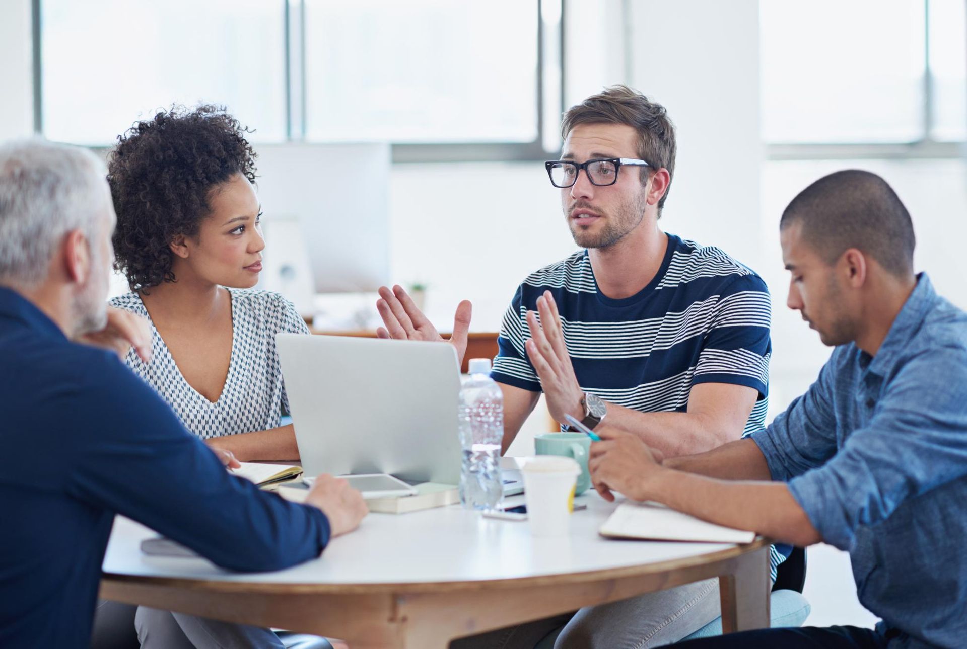 Four diverse colleagues collaborating around a table, discussing ideas.