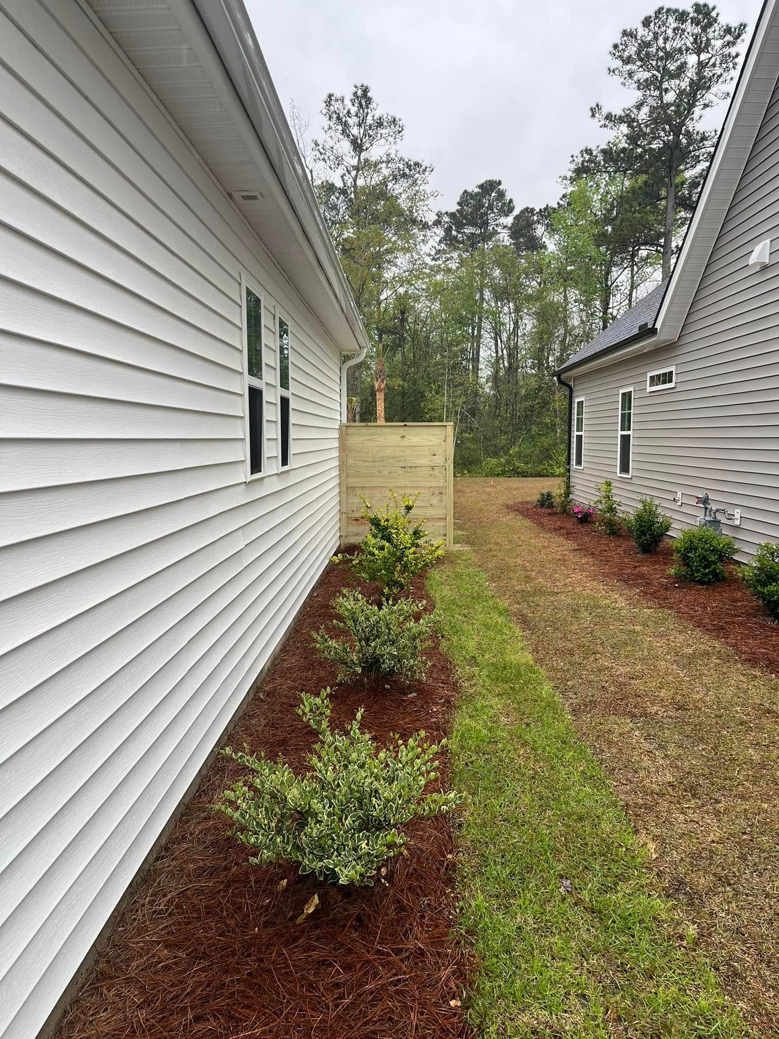A white house with a wooden fence in the backyard.