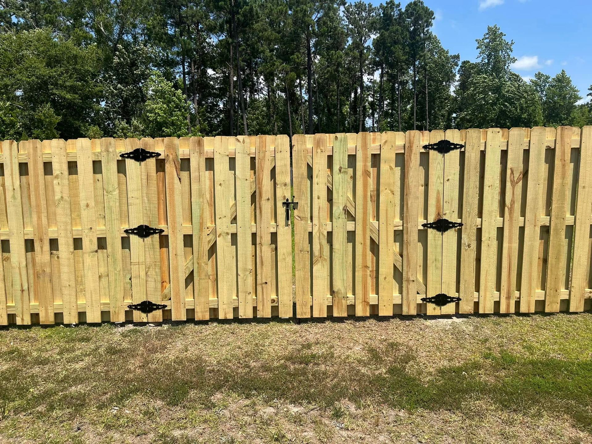 A wooden fence is sitting in the middle of a grassy field.