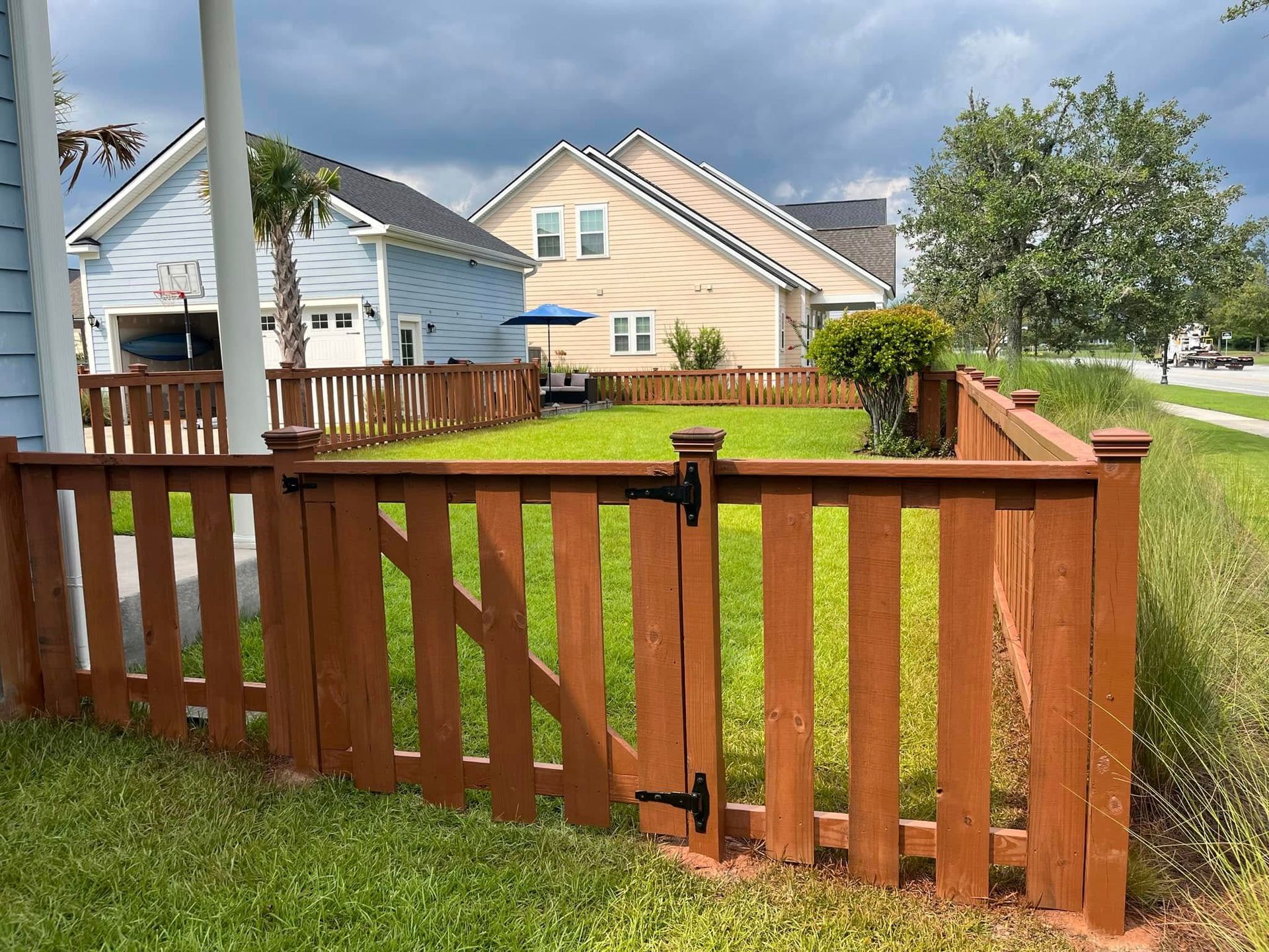 A wooden fence with a gate in front of a house.