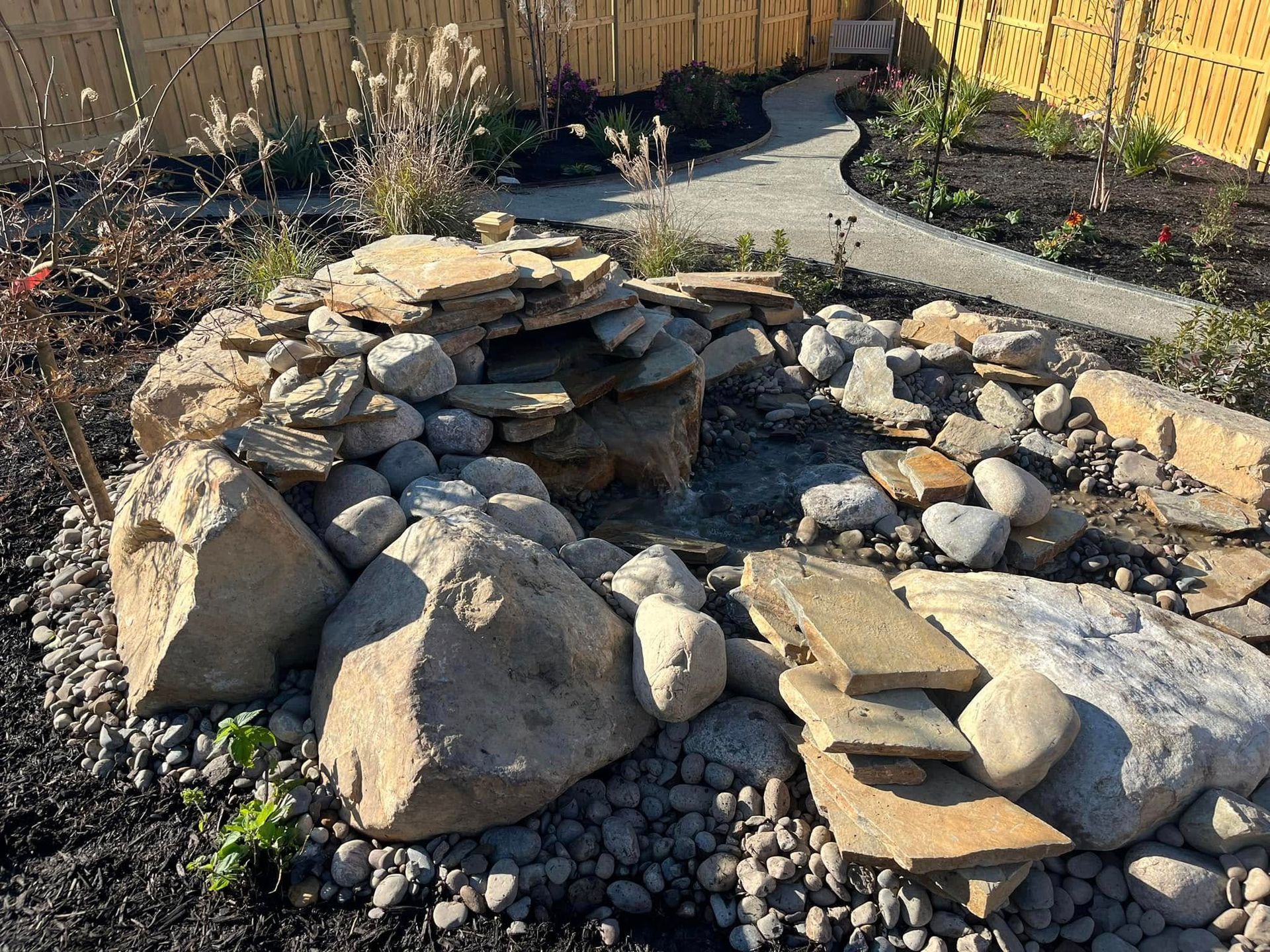 A rock garden with a waterfall in the middle of it.