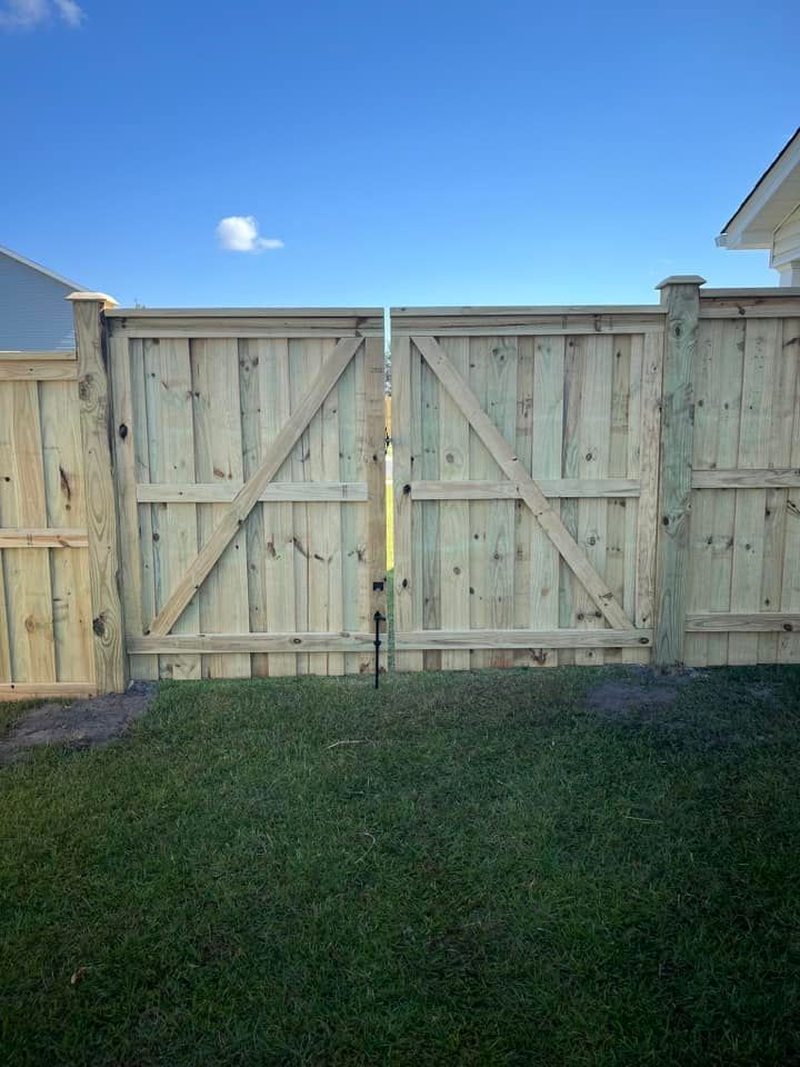 A wooden fence with a gate in the backyard of a house.