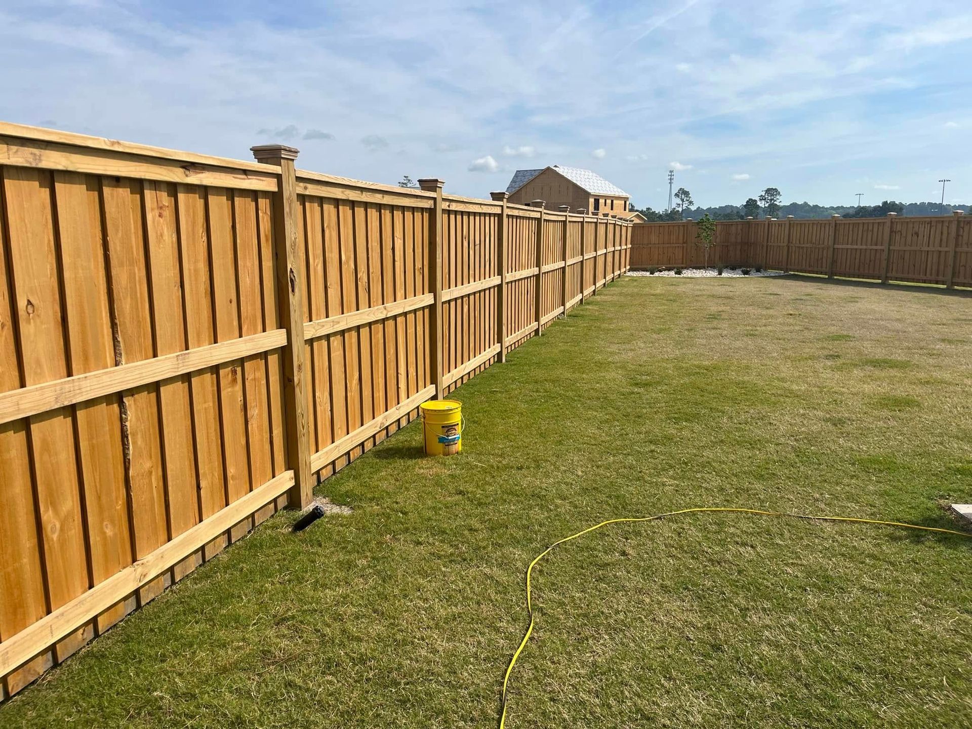 A wooden fence is sitting on top of a lush green lawn.