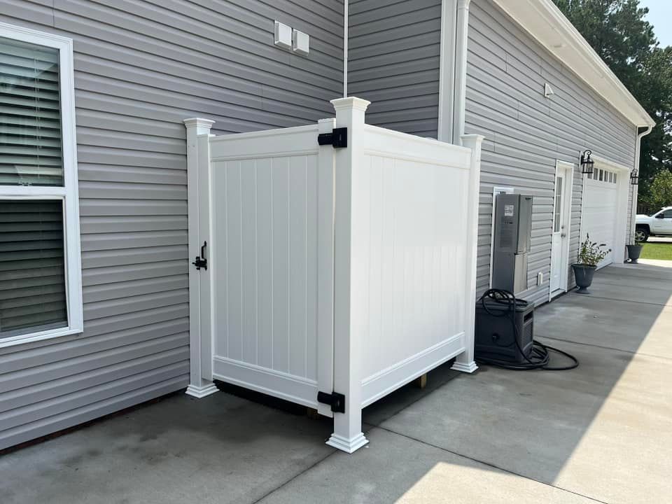A white fence is sitting in front of a house.