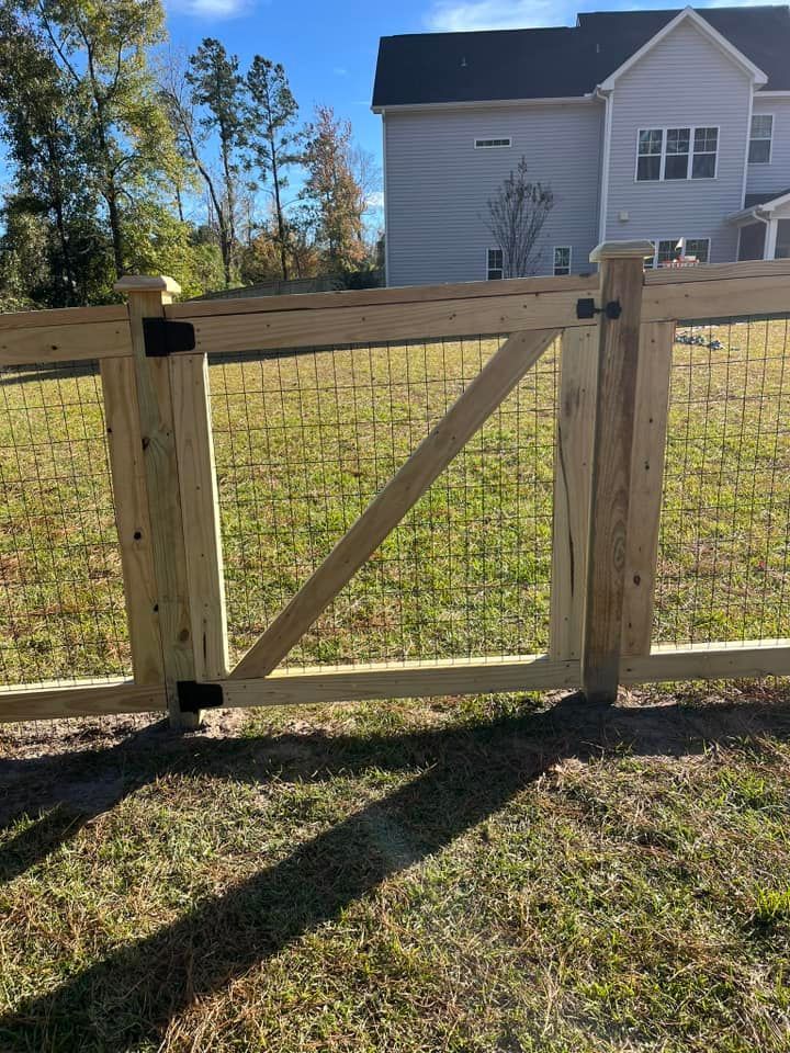 A wooden fence with a gate in front of a house.