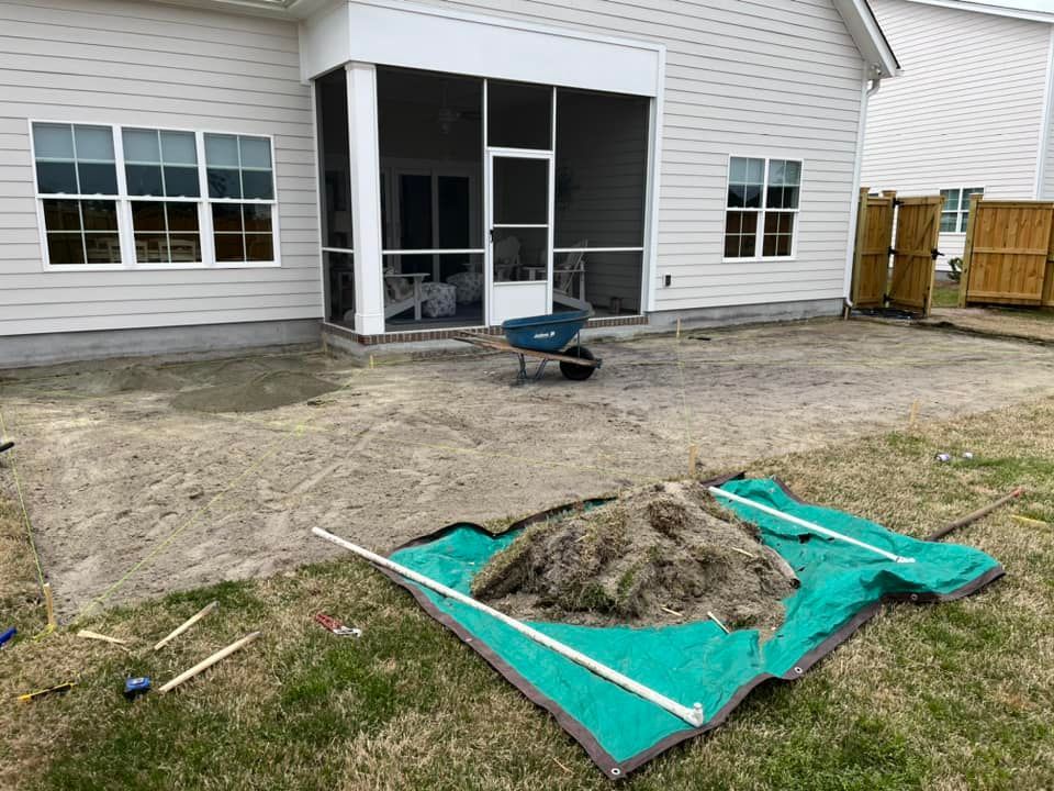 A house with a screened in porch and a wheelbarrow in front of it.