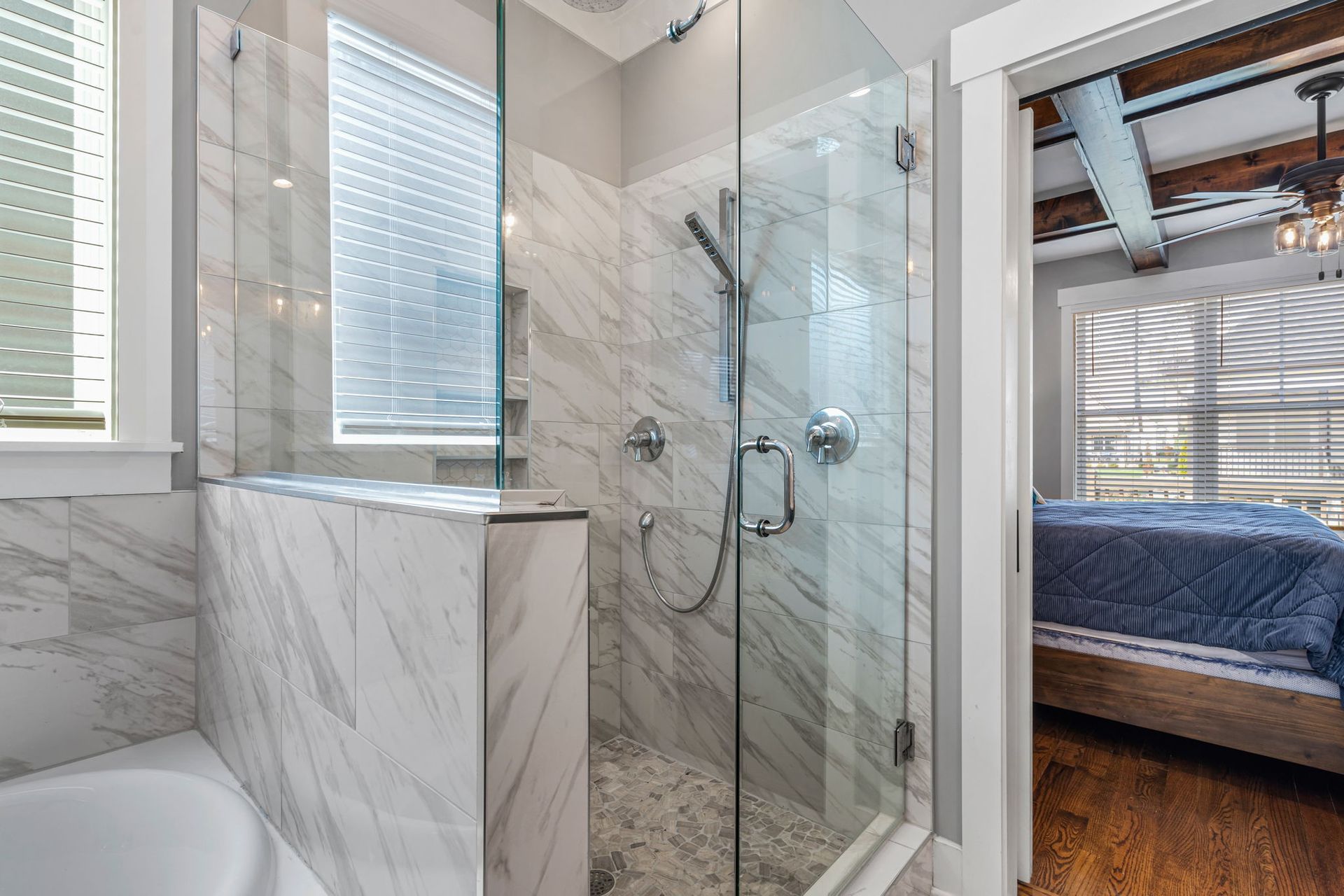 Custom home builder in Chattanooga showcases modern bathroom with glass shower, marble tile, and luxury finishes.