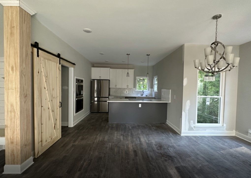 Fully renovated kitchen and dining area featuring barn door, pendant lighting, and updated finishes — home remodeling Chattanooga.