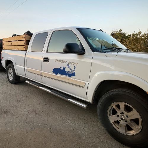A white truck with the word port city on the side