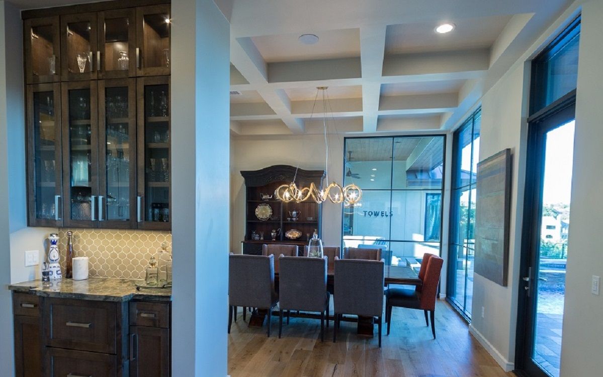 Elegant dining room with a long table, high windows, and built-in cabinetry.
