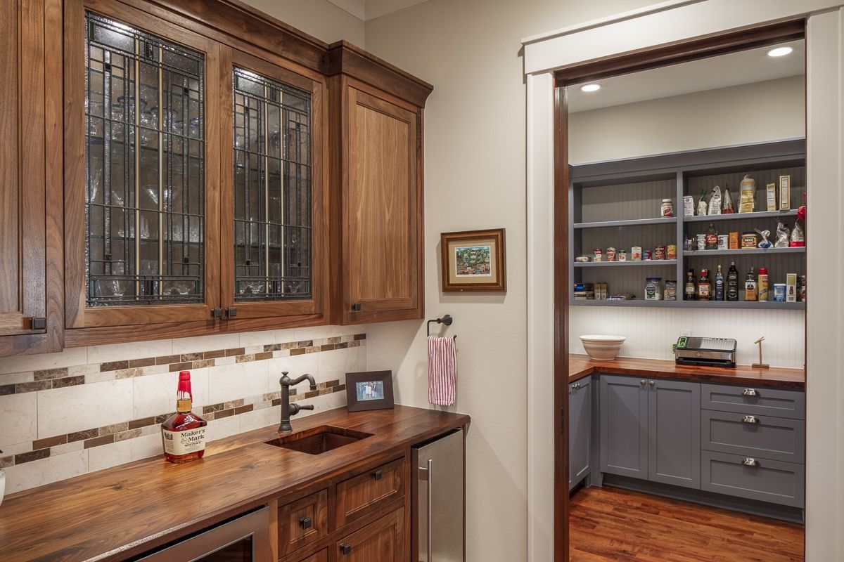Kitchen with wood cabinets, countertops, and pantry access, with a small picture on the wall.