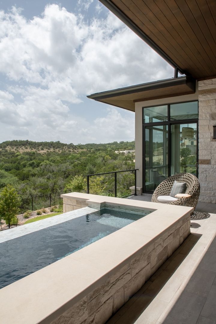Poolside patio with a small pool, glass doors, and a view of trees.