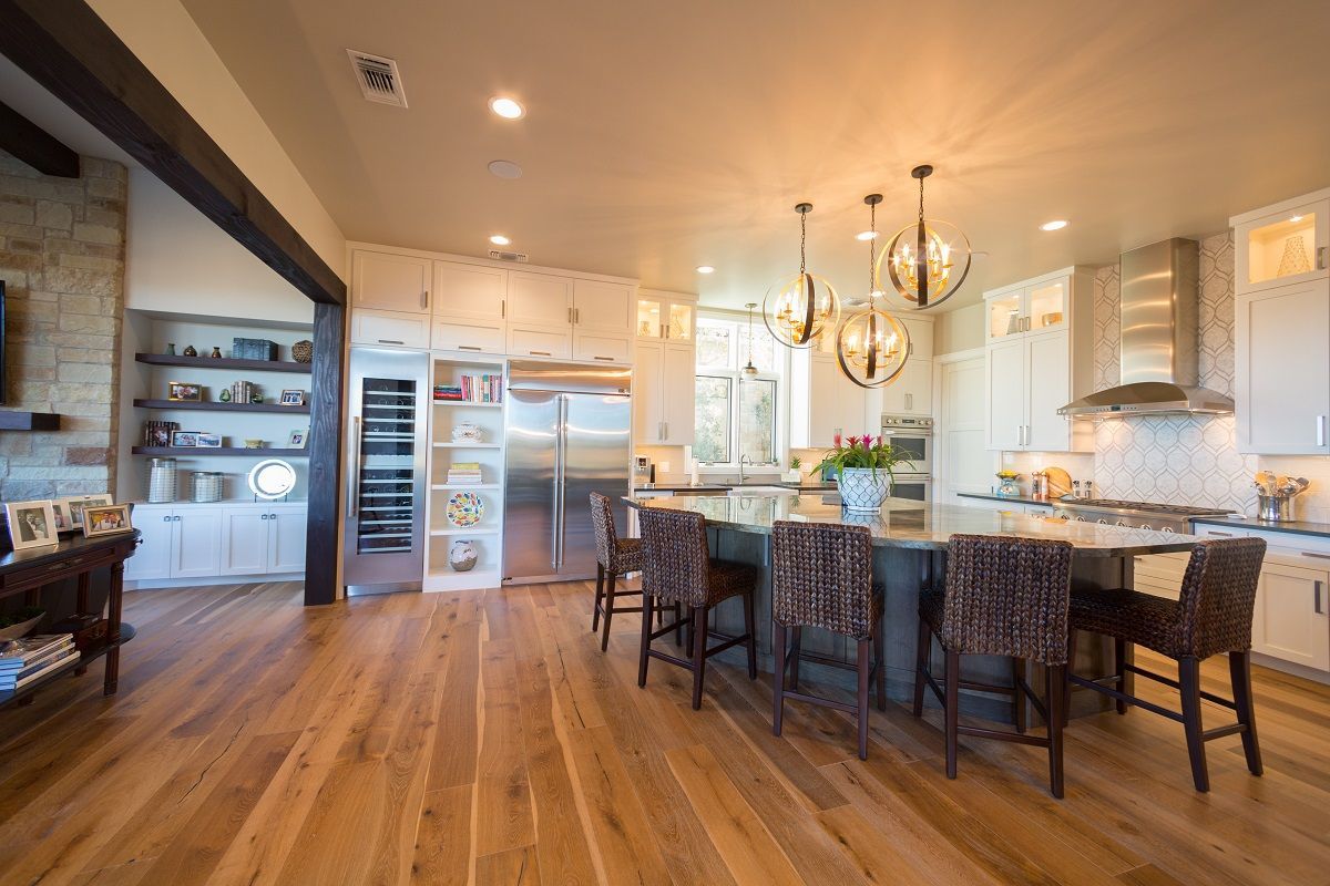 Spacious kitchen with island, hardwood floors, and large refrigerator.